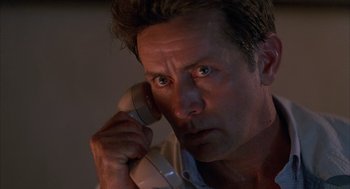 Movie still from “The Believers” (1987), directed by John Schlesinger – A person talking on a phone; Close Up shot, Low angle