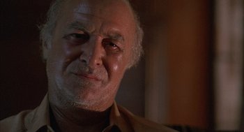 Movie still from “The Believers” (1987), directed by John Schlesinger – An older man with a beard and mustache; Close Up shot, Low angle