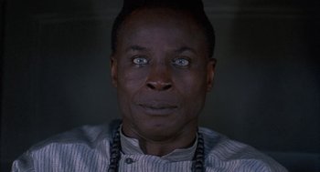 Movie still from “The Believers” (1987), directed by John Schlesinger – A person wearing a necklace; Close Up shot, High angle