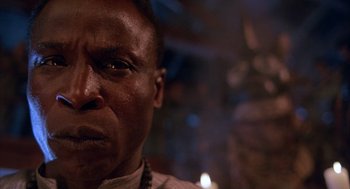 Movie still from “The Believers” (1987), directed by John Schlesinger – A man's face in a dark room; Close Up shot, Low angle