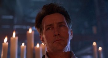 Movie still from “The Believers” (1987), directed by John Schlesinger – A person with candles in the background; Close Up shot, Low angle