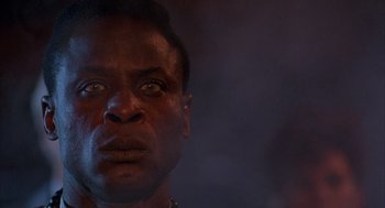 Movie still from “The Believers” (1987), directed by John Schlesinger – A man's face in the dark; Close Up shot, Low angle