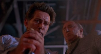 Movie still from “The Believers” (1987), directed by John Schlesinger – A man holding a microphone in front of another man; Close Up shot, Low angle