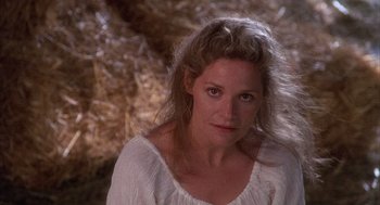 Movie still from “The Believers” (1987), directed by John Schlesinger – A woman in a white shirt is looking at the camera; Close Up shot, Over the shoulder angle