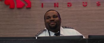 Movie still from “The Belko Experiment” (2016), directed by Greg McLean – A man wearing a uniform sitting in front of a wall; Close Up shot, Over the shoulder angle