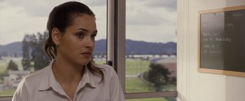 Movie still from “The Belko Experiment” (2016), directed by Greg McLean – A woman sitting in front of a large window; Close Up shot, Over the shoulder angle
