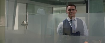 Movie still from “The Belko Experiment” (2016), directed by Greg McLean – A man standing in front of a mirror in a room; Medium shot, Over the shoulder angle