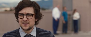 Movie still from “The Belko Experiment” (2016), directed by Greg McLean – A person wearing glasses and a tie; Close Up shot, Over the shoulder angle