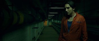 Movie still from “The Belko Experiment” (2016), directed by Greg McLean – A woman standing in a dark room with wires hanging from the ceiling; Medium shot, Low angle