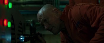 Movie still from “The Belko Experiment” (2016), directed by Greg McLean – A bald headed man looking at a cell phone; Close Up shot, Low angle