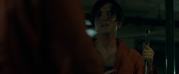 Movie still from “The Belko Experiment” (2016), directed by Greg McLean – A man with long dark hair is looking at the camera; Close Up shot, Over the shoulder angle