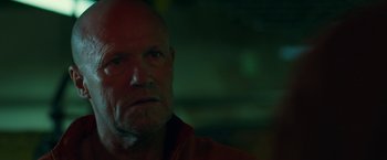 Movie still from “The Belko Experiment” (2016), directed by Greg McLean – A man with a bald head and a goatee; Close Up shot, Low angle