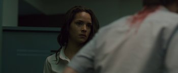 Movie still from “The Belko Experiment” (2016), directed by Greg McLean – A woman in a white shirt is looking at the camera; Close Up shot, Over the shoulder angle