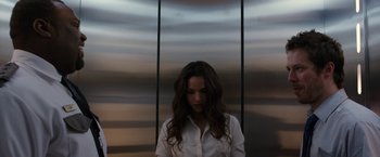 Movie still from “The Belko Experiment” (2016), directed by Greg McLean – A woman standing in front of an elevator with her head down; Medium shot, Low angle