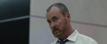 Movie still from “The Belko Experiment” (2016), directed by Greg McLean – A person wearing a shirt and tie; Close Up shot, Low angle