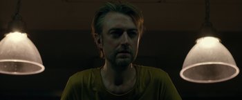 Movie still from “The Belko Experiment” (2016), directed by Greg McLean – A person wearing a yellow shirt; Close Up shot, Low angle