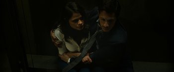 Movie still from “The Belko Experiment” (2016), directed by Greg McLean – A man and a woman sitting next to each other holding a guitar; Medium shot, High angle