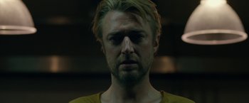 Movie still from “The Belko Experiment” (2016), directed by Greg McLean – A person wearing a yellow shirt; Close Up shot, Low angle