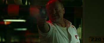 Movie still from “The Belko Experiment” (2016), directed by Greg McLean – A man holding a gun in his right hand; Close Up shot, Low angle