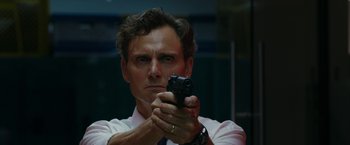 Movie still from “The Belko Experiment” (2016), directed by Greg McLean – A man holding a gun while wearing a tie; Close Up shot, Over the shoulder angle