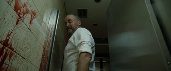 Movie still from “The Belko Experiment” (2016), directed by Greg McLean – A man in a white shirt is standing in a room; Medium shot, Low angle