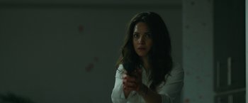Movie still from “The Belko Experiment” (2016), directed by Greg McLean – A woman holding a cell phone in her hand; Close Up shot, Over the shoulder angle