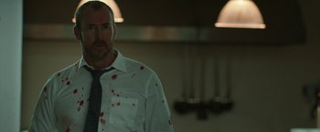 Movie still from “The Belko Experiment” (2016), directed by Greg McLean – A man in a white dress shirt and tie with blood on his shirt; Close Up shot, Over the shoulder angle