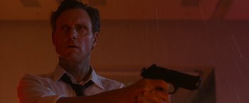 Movie still from “The Belko Experiment” (2016), directed by Greg McLean – A man holding a gun while standing in the rain; Close Up shot, Low angle