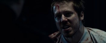 Movie still from “The Belko Experiment” (2016), directed by Greg McLean – A person with blood on his face; Close Up shot, Over the shoulder angle