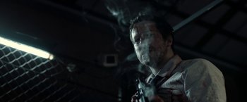 Movie still from “The Belko Experiment” (2016), directed by Greg McLean – A man holding a gun while smoking a cigarette; Close Up shot, Low angle