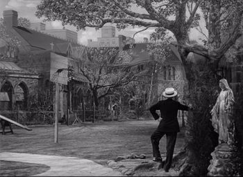 Movie still from “The Bells of St. Mary's” (1945), directed by Leo McCarey – A man standing in front of a basketball hoop; Extreme Wide shot, High angle