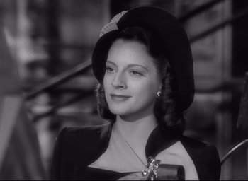 A black and white photo of a woman wearing a hat