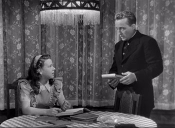 Movie still from “The Bells of St. Mary's” (1945), directed by Leo McCarey – A man and a woman sitting at a dining room table; Medium shot, High angle