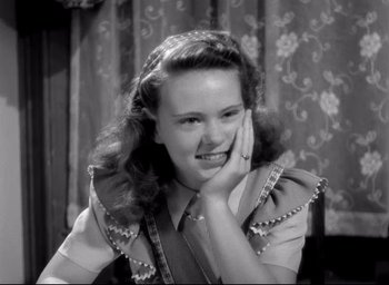 Movie still from “The Bells of St. Mary's” (1945), directed by Leo McCarey – A young woman is smiling while holding her hand to her face; Close Up shot, High angle