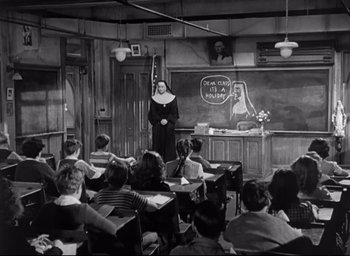Movie still from “The Bells of St. Mary's” (1945), directed by Leo McCarey – An old black and white photo of a nun teaching a class; Wide shot, High angle