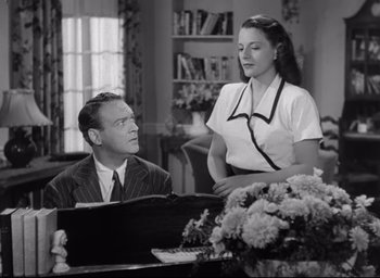 Movie still from “The Bells of St. Mary's” (1945), directed by Leo McCarey – A man and a woman sitting at a table; Medium shot, Low angle