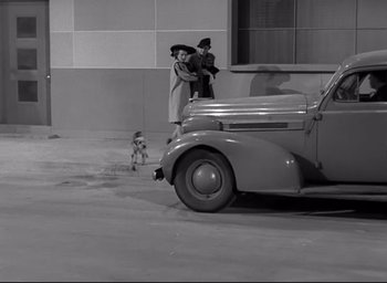Movie still from “The Bells of St. Mary's” (1945), directed by Leo McCarey – A couple of people standing next to a car; Wide shot, High angle