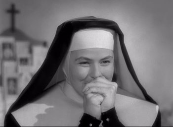 Movie still from “The Bells of St. Mary's” (1945), directed by Leo McCarey – A woman in a nun's outfit with her hands clasped together; Close Up shot, Low angle
