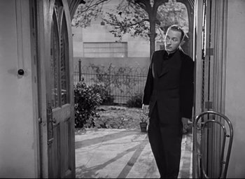 Movie still from “The Bells of St. Mary's” (1945), directed by Leo McCarey – A black and white photo of a man in a suit; Medium shot, High angle