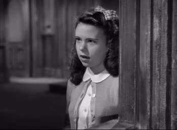 Movie still from “The Bells of St. Mary's” (1945), directed by Leo McCarey – A young woman standing in front of a wooden door; Close Up shot, High angle
