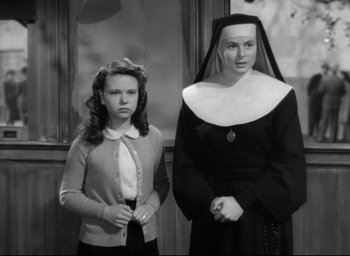 Movie still from “The Bells of St. Mary's” (1945), directed by Leo McCarey – A young woman and a nun standing next to each other; Medium shot, High angle