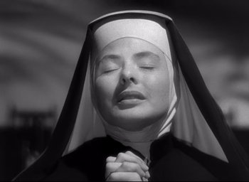 Movie still from “The Bells of St. Mary's” (1945), directed by Leo McCarey – A woman in a nun's outfit is praying with her eyes closed; Close Up shot, Low angle
