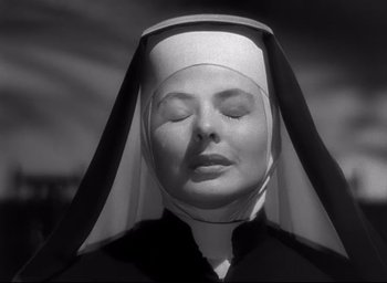 Movie still from “The Bells of St. Mary's” (1945), directed by Leo McCarey – A nun with her eyes closed in a black and white photo; Close Up shot, Low angle