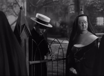 Movie still from “The Bells of St. Mary's” (1945), directed by Leo McCarey – A man and a woman standing next to each other near a fence; Medium shot, Over the shoulder angle