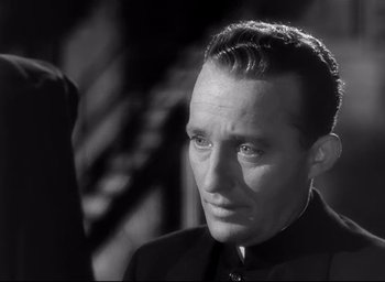 Movie still from “The Bells of St. Mary's” (1945), directed by Leo McCarey – A black and white photo of a man in a suit; Close Up shot, Over the shoulder angle