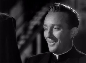 Movie still from “The Bells of St. Mary's” (1945), directed by Leo McCarey – A black and white photo of a man smiling; Close Up shot, Low angle