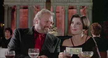 Movie still from “The Belly of an Architect” (1987), directed by Peter Greenaway – A man and a woman sitting next to each other at a table; Close Up shot, Low angle