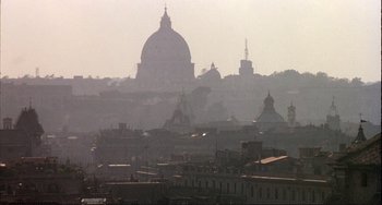 Movie still from “The Belly of an Architect” (1987), directed by Peter Greenaway – A view of a city skyline with a large dome in the background; Extreme Wide shot, Low angle