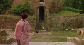Movie still from “The Belly of an Architect” (1987), directed by Peter Greenaway – A person standing in front of a gate; Extreme Wide shot, Low angle