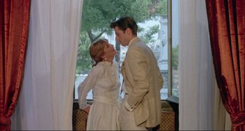 Movie still from “The Belly of an Architect” (1987), directed by Peter Greenaway – A man and a woman standing next to each other; Medium shot, Low angle